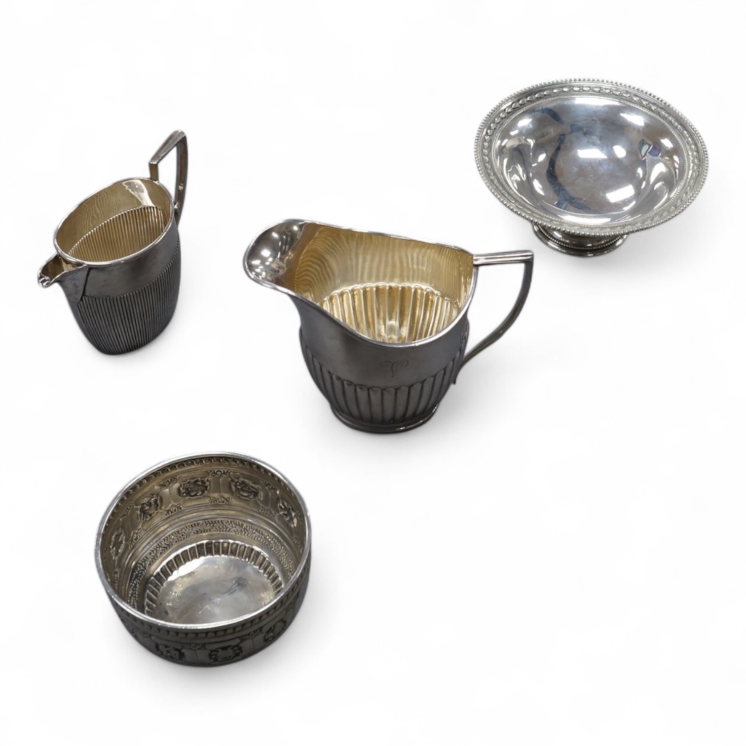 A George V demi-fluted silver cream jug, by William Hutton & Sons Ltd, Sheffield, 1922, height 98mm, together with a smaller silver ream jug, a small silver pedestal bowl and a late Victorian silver Anglo-Indian sugar bo